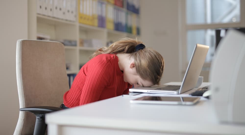 Woman-Sitting-on-Chair-While-Leaning-on-Laptop